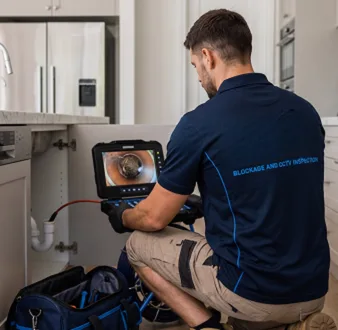 Plumber clearing a blocked toilet in a Ingleburn bathroom